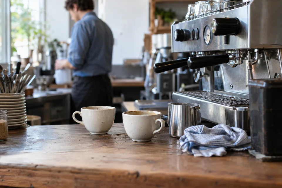 Coffee cups and an espresso machine on a cafe counter